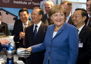 Illustration for article titled Why Is Angela Merkel Always Palling Around With Robots?